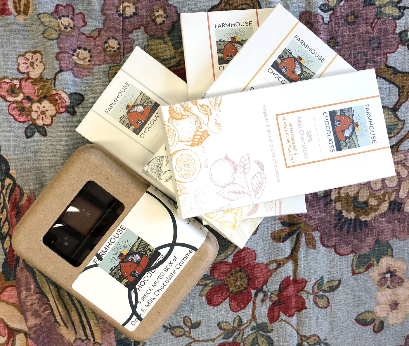 The Showstopper bundle: all four organic bars fanned over nine-piece caramel boxes with dark chocolate truffles