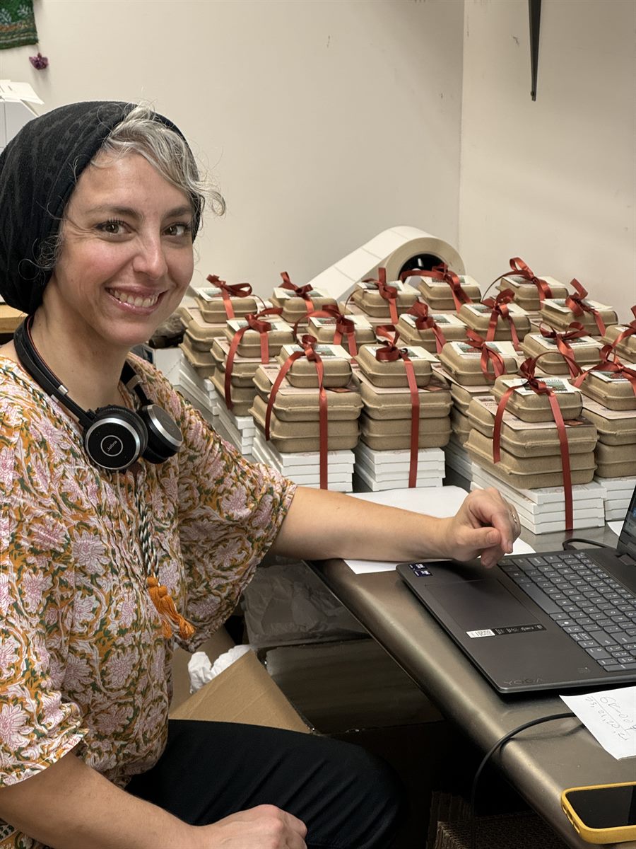 Eliza assembling ribbon-tied corporate gift boxes